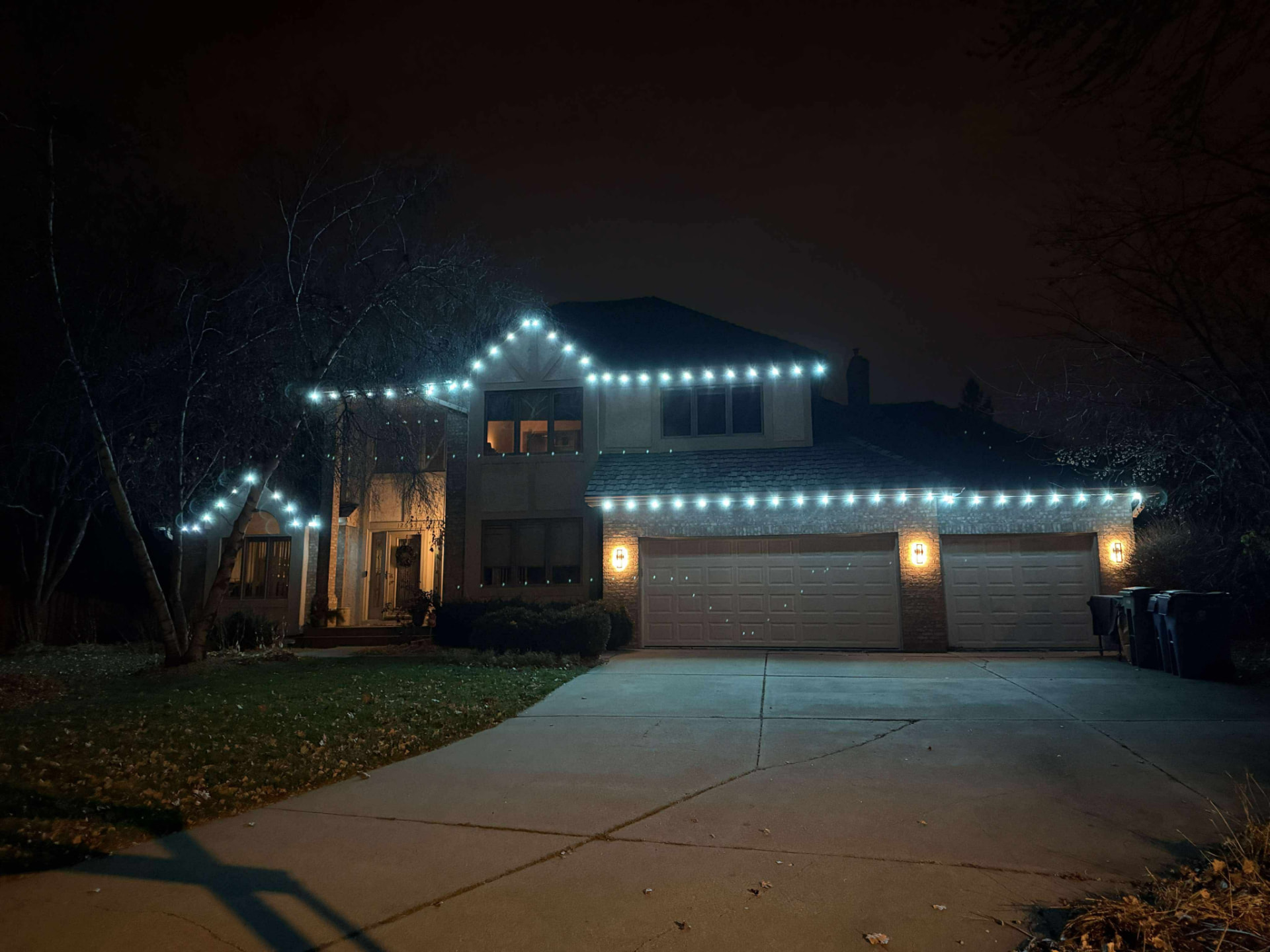 Large home outlined in crisp white permanent LED roofline lighting