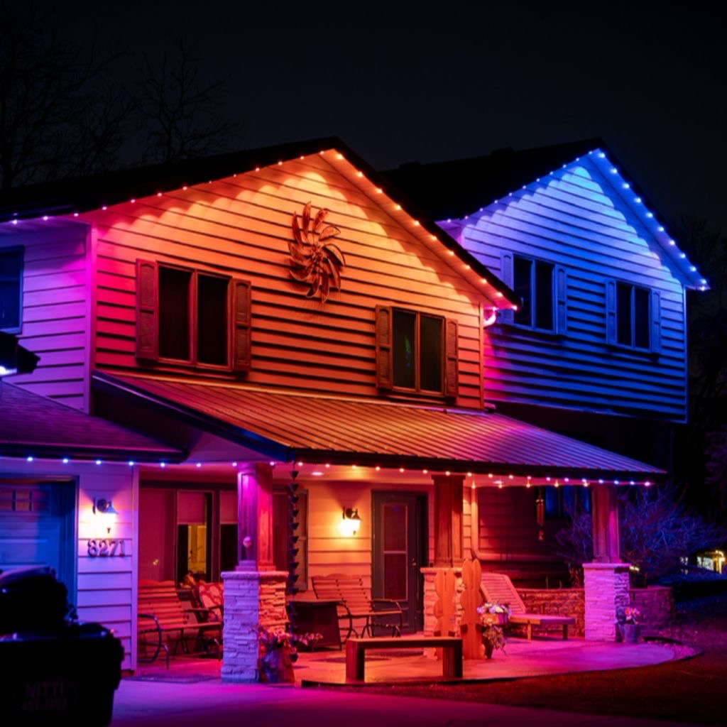 Home lit with multicolor permanent LED lighting along rooflines and porch
