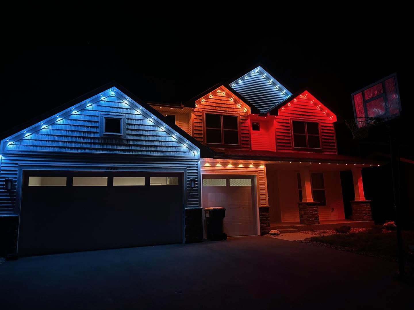 Home with red, white and blue permanent LED lighting across gables and porch