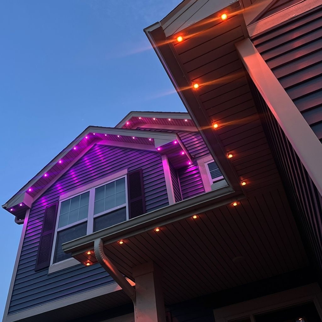 Close-up of purple and orange permanent LED lights under the eaves